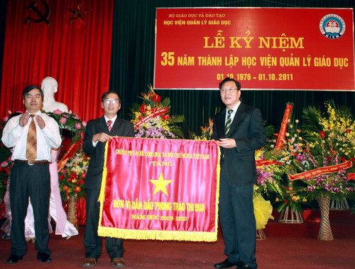 Bộ trưởng Phạm Vũ Luận tặng cờ thi đua của Chính phủ cho 888B19 phiên bản mới QLGD. Ảnh, gdtd.vn