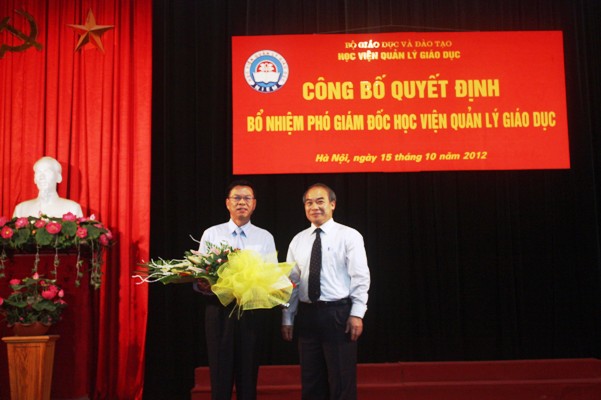Thứ trưởng Bộ GD&ĐT Nguyễn Vinh Hiển trao quyết định và chúc mừng GS.TSKH Nguyễn Mạnh Hùng. Ảnh: VA